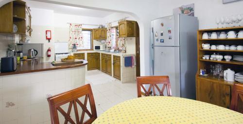a kitchen with a refrigerator and a table and chairs at Le Manglier in Pointe Larue