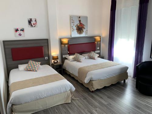 a hotel room with two beds and a window at Les Rives du Plantié in Le Temple-sur-Lot