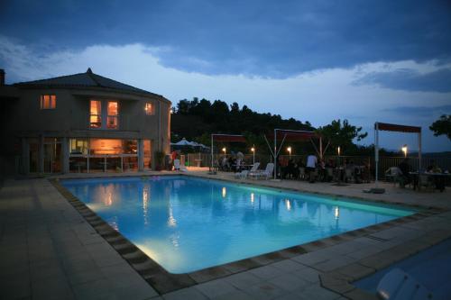 a large swimming pool in front of a house at Domaine Plein Sud in Bruzac