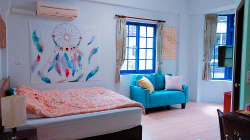 1 dormitorio con 1 cama y 1 silla azul en Star Coffee & Homestay, en Nanzhuang