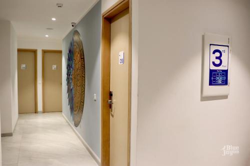 a hallway with a number three sign on a wall at The Blue Jay Hostel - Dorms & Rooms in Rishīkesh