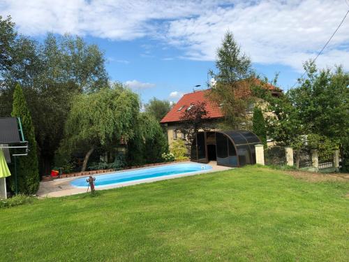 a swimming pool in a yard next to a house at Holiday house EWA in Meszna Opacka