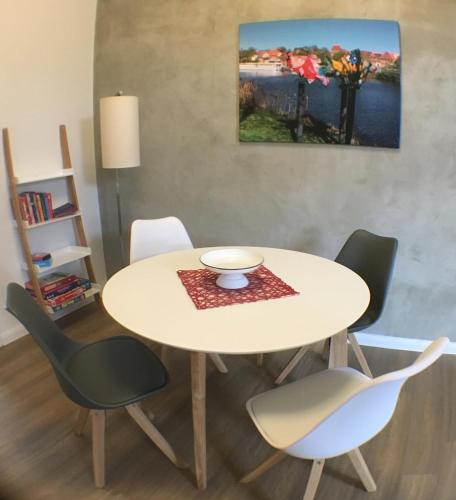 a table with four chairs and a bowl on it at Das BilderbuchCafe - Ferien - Apartment NO 3 - Markt 7 in Havelberg