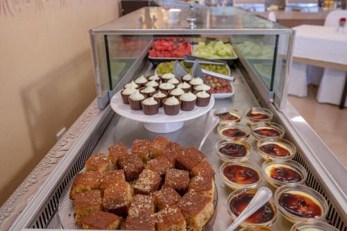 a buffet filled with different types of pastries and desserts at Art Hotel Debono in Gouvia