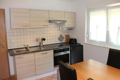 cocina con fregadero y nevera negra en Ferienwohnung Jasmin in Schönau bei Heidelberg FEWO 2, en Schönau