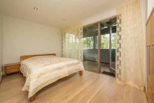 um quarto com uma cama e uma grande janela em Golf Villa near Tallinn em Manniva