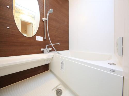 W łazience znajduje się umywalka i lustro. w obiekcie COTO Tokyo Shibuya 3 w Tokio