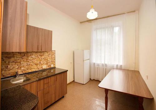 a kitchen with a refrigerator and a table in it at Zhemchuzhina Kavkaza Hotel in Zheleznovodsk