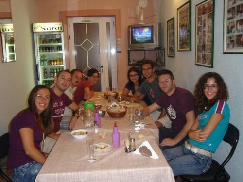 a group of people sitting around a table at Saraj Guest House in Kulen Vakuf
