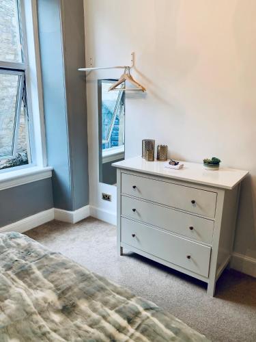 - une chambre avec une commode blanche et une fenêtre dans l'établissement Flat 2 Struan house, à Pitlochry