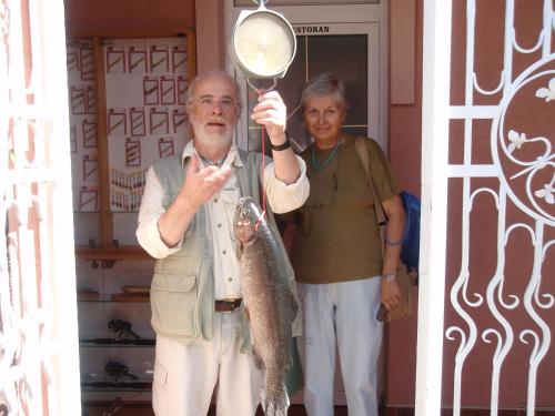 a man holding a fish in a magnifying glass at Saraj Guest House in Kulen Vakuf