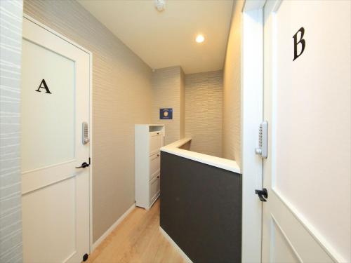 a hallway with a white door and a black drawer at COTO Tokyo Shibuya 3 in Tokyo