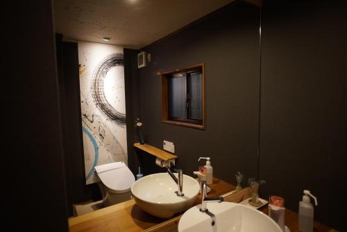 城崎温泉 但馬屋-Tajimaya- في تويوكا: حمام مع حوض أبيض ومرحاض