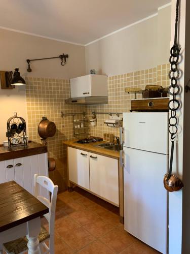 a kitchen with a white refrigerator and a table at Elfoghiro' in Ateleta