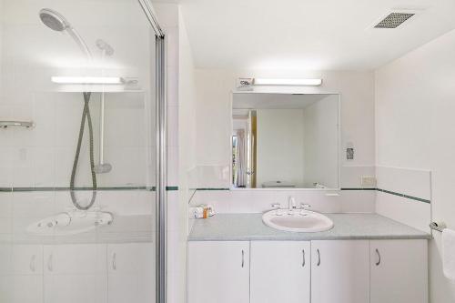 a bathroom with two sinks and a shower at White Crest Apartments in Hervey Bay