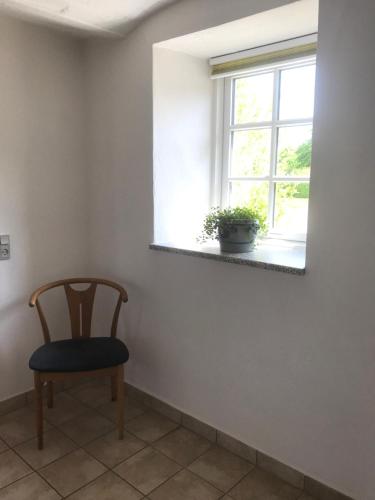 a chair in a room with a window at Brunbjerg Apartments in Billund