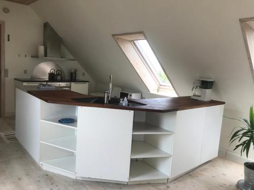a kitchen with a white island with a sink at Brunbjerg Apartments in Billund