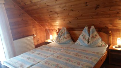 a bedroom with a bed in a wooden room at Ferienhaus Groß in Steinreib