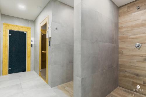 kabina prysznicowa w pokoju ze ścianą w obiekcie DELUXE 38 Bałtycka 6 by Jantar Apartamenty Kołobrzeg w Kołobrzegu