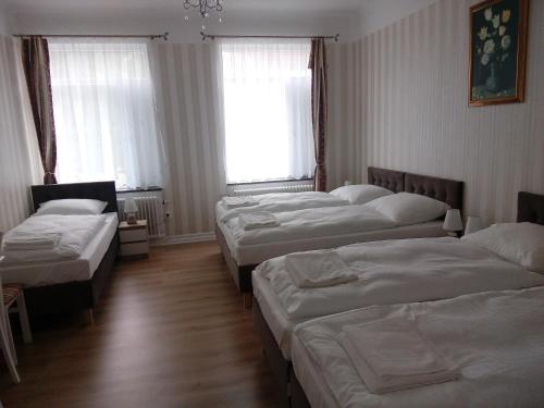 a group of beds in a room with windows at Liahof in Ullared