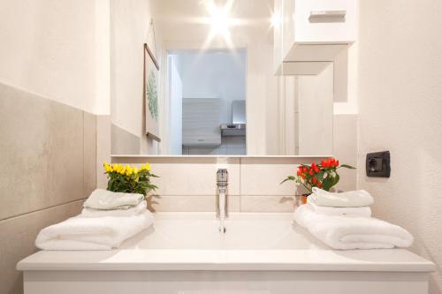 ein Badezimmer mit einem Waschbecken mit Blumen und einem Spiegel in der Unterkunft Duplex Apartment in pieno centro in Ferrara