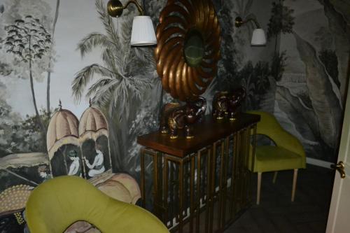 a living room with a wall with a painting at Ayhan Hotel in Aktobe