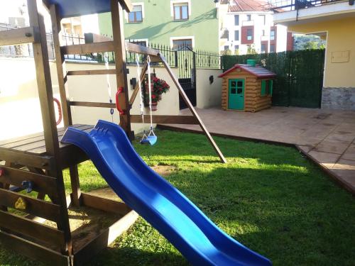 a playground with a blue slide in a yard at Toño el Alguacil in Selaya