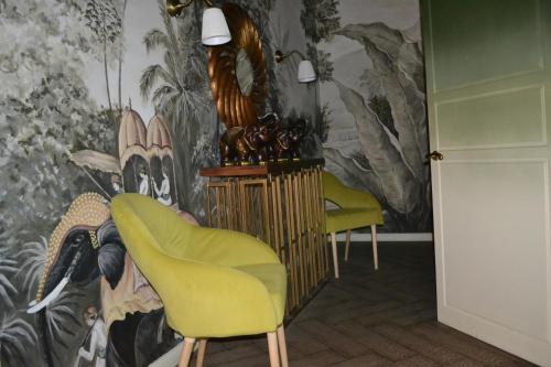 アクトベにあるAyhan Hotelの椅子2脚と壁画のある部屋