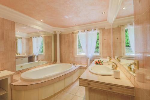 une grande salle de bain avec une baignoire et un lavabo dans l'établissement LA ROHIERE - Tourrette-Levens, à Tourrette-Levens