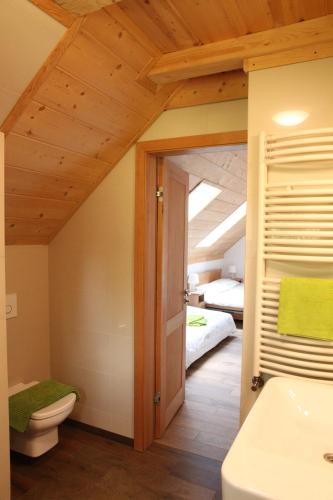 a bathroom with a sink and a toilet and a bed at Ośrodek Wideta in Wetlina