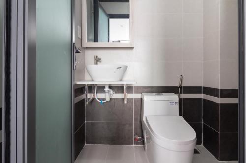 a bathroom with a white toilet and a sink at The Art - Tina Hotel and Apartments in Ho Chi Minh City