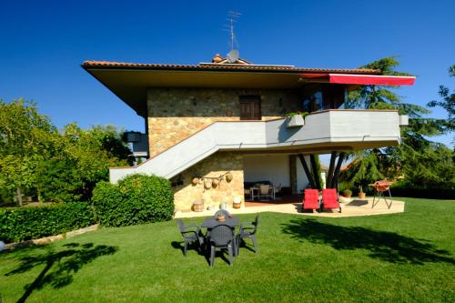 a house with a lawn in front of it at Il Melograno - San Quirico d'Orcia in San Quirico dʼOrcia