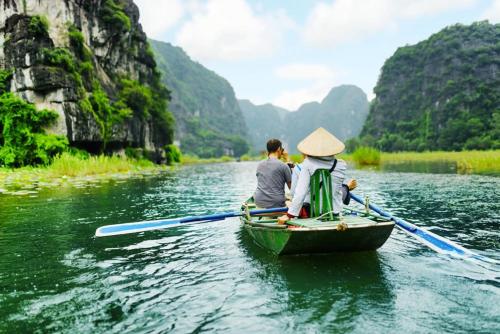 zwei Menschen in einem Boot auf einem Fluss in der Unterkunft Hanoi Culture Hostel in Hanoi