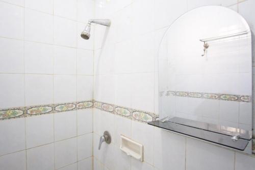 een badkamer met een douche en een spiegel bij RedDoorz near Pantai Falajawa Ternate in Ternate