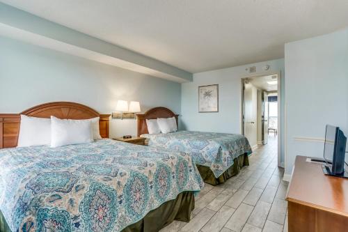 a hotel room with two beds and a flat screen tv at Oceanfront Paradise in the Heart of Myrtle Beach in Myrtle Beach