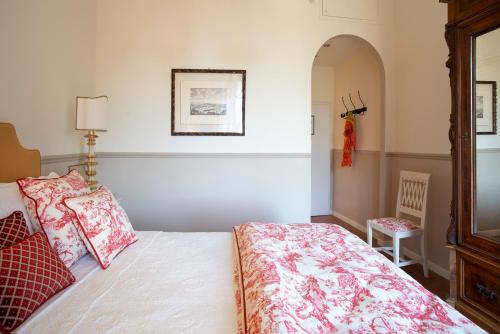 a bedroom with a bed with red and white pillows at Palazzo Malaspina B&B in Tavarnelle in Val di Pesa