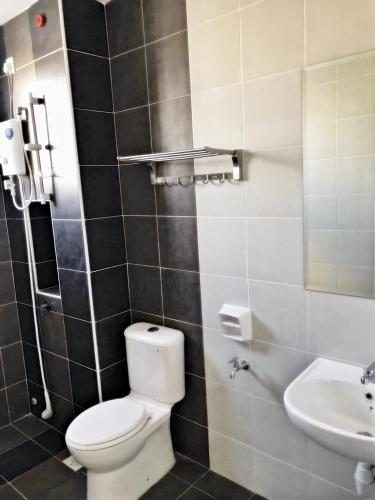 a bathroom with a toilet and a sink at Desaru Cosy Homestay - near WaterPark, Beach, Rapid -Wifi, TVbox, Steamboat, BBQ Available in Desaru