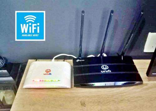 a wii router sitting on a table next to a box at Desaru Cosy Homestay - near WaterPark, Beach, Rapid -Wifi, TVbox, Steamboat, BBQ Available in Desaru