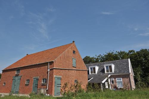 an old brick building next to a house at Villa Magnolia in Oostkapelle