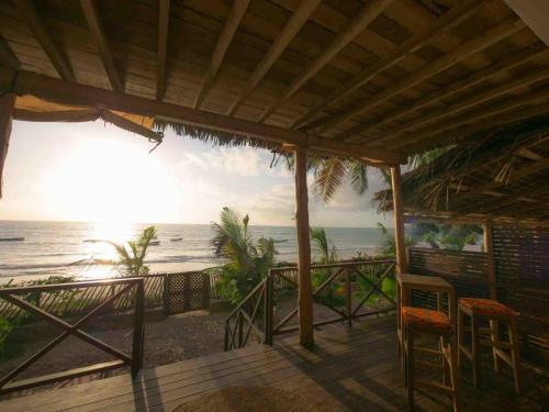 a porch with chairs and a view of the ocean at Hekaya Zanzibar in Pingwe