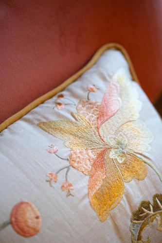 a bed with a white blanket with flowers on it at Palazzo Malaspina B&B in Tavarnelle in Val di Pesa