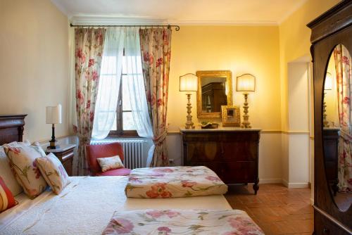 a bedroom with a bed and a dresser and a mirror at Palazzo Malaspina B&B in Tavarnelle in Val di Pesa
