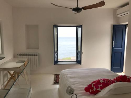 a bedroom with a bed and a window and a desk at Casa Isabella in Malfa