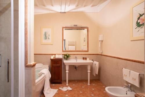 a bathroom with a sink and a toilet and a mirror at Palazzo Malaspina B&B in Tavarnelle in Val di Pesa