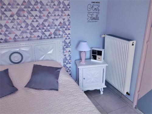 um quarto com uma cama e uma mesa com um candeeiro em Chambre du Hamel em Avroult