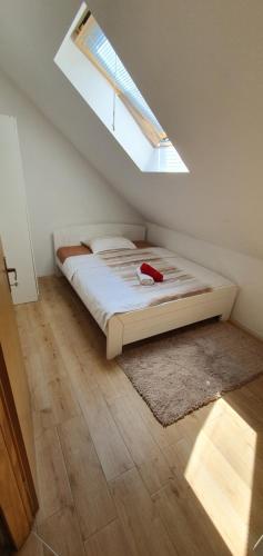 a bedroom with a bed with a window and a rug at VILA LASOVIC + POOL + JACUZZI + SAUNA in Tuhelj