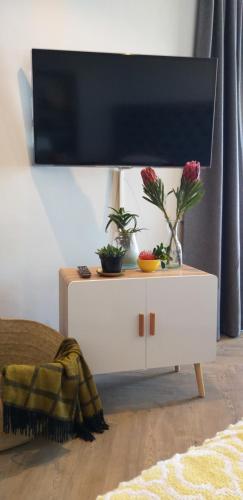 a white dresser with a tv on top of it at 365 Sunset Self Catering Apartments in Noordhoek