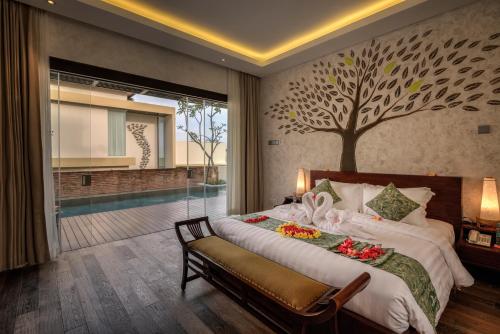 a bedroom with a bed with a tree mural on the wall at The Miracle Villa Nusa Dua in Nusa Dua