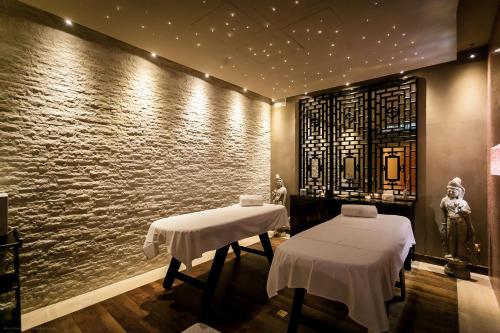 two massage tables in a room with a stone wall at Hotel Villa e Palazzo Aminta in Stresa