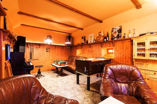a living room with a ping pong table and leather chairs at Pension U Dvou čápů in Chocerady